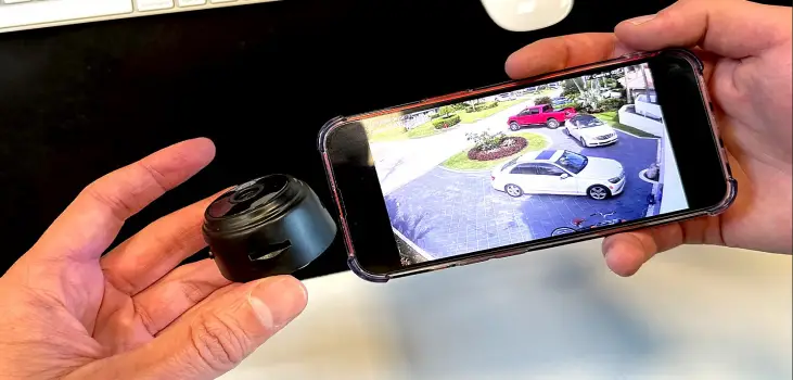 person holds MiniPix camera next to phone